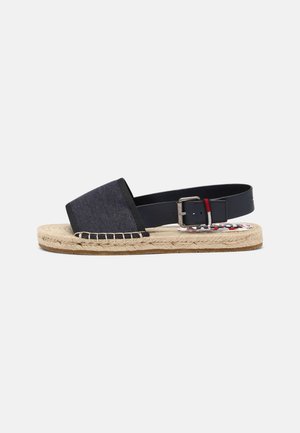 Espadrillesandal med navy blåt stof foran, navy justerbar ankelrem med sølvspænde, jutesål og gummiydersål på hvid baggrund.