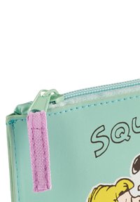 Custodia a zip verde menta con tirazip in tessuto viola, caratterizzata da un design in stile cartoon e dettagli di cucitura visibili sulla superficie esterna.