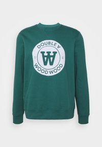 Zelená mikina z bavlny s kulatým motivem obsahujícím nápis 'DOUBLE A WOOD WOOD' a stylizované logo 'W' uprostřed.