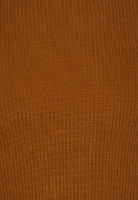 Geribbelde tricotstof in een warme amberkleur, met fijne verticale strepen en een zachte textuur, geschikt voor kleding of accessoires.