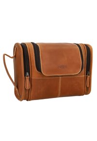 Brązowa skórzana kosmetyczka z klapką, dwoma suwakami na górze i bocznym uchwytem. Posiada detale w postaci przeszyć i gładką teksturę.