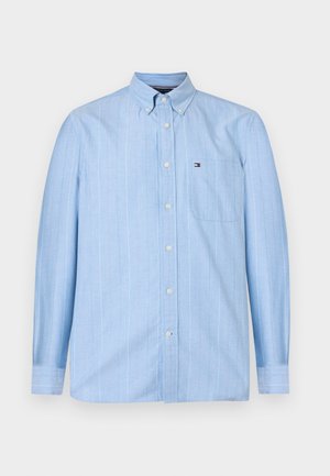 Chemise à manches longues bleu clair avec de fines rayures verticales, col boutonné, poche poitrine et petit logo sur la poche.