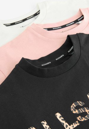 Trzy t-shirty z okrągłym dekoltem w kolorze czarnym, różowym i białym, wykonane z miękkiego materiału bawełnianego. Czarna koszulka ma szczegóły z nadrukiem w panterkę.