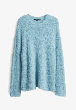 Lichtblauwe donzige gebreide trui met een ronde hals en lange mouwen. Zachte textuur en een losse pasvorm met een zoom die aan de achterkant iets langer is.