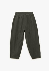 Donkergroene, losvallende broek met een elastische tailleband en gestikte verticale naden, plat gelegd op een witte achtergrond.