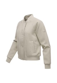 Veste bomber beige clair avec col, poignets et bas côtelés, fermeture à boutons-pression à l'avant, poches latérales et un écusson circulaire sur la manche gauche.