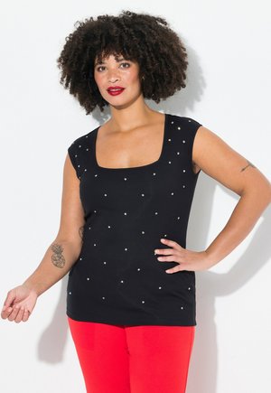Zwart aansluitend topje met een vierkante halslijn en korte mouwen, versierd met zilveren studs, gecombineerd met felrode broek. Glad textuur.