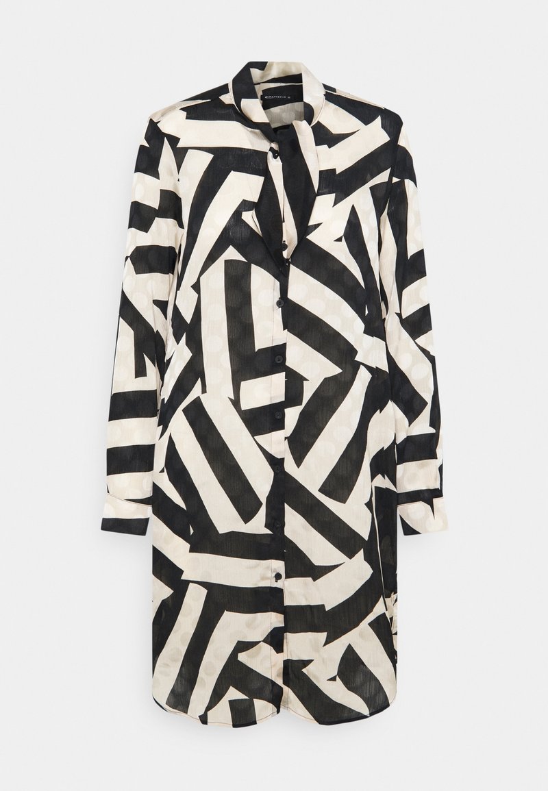 Chemise à motif noir et blanc en tissu léger, dotée d'un col, de manches longues et d'une fermeture à boutons. Éléments de design géométrique.