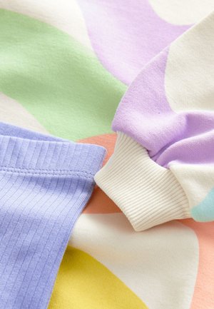 Pull en coton aux couleurs pastel : lavande, vert menthe, pêche et crème, avec des poignets à côtes et un tissu doux et texturé.