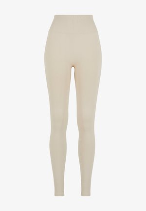 Beige Leggings aus dehnbarem Stoff mit hohem Bund; glatte Textur, figurbetonte Silhouette, keine sichtbaren Muster oder Hardware-Details.