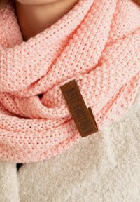 Gehaakte roze sjaal van zachte garen, met een opvallend bruin leren label. Gestructureerd, gezellig ontwerp met plooien en een los gebreid patroon.