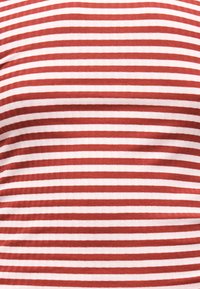 Κοντινό πλάνο υφάσματος με οριζόντιες κόκκινες και λευκές ρίγες σε σταθερό μοτίβο.