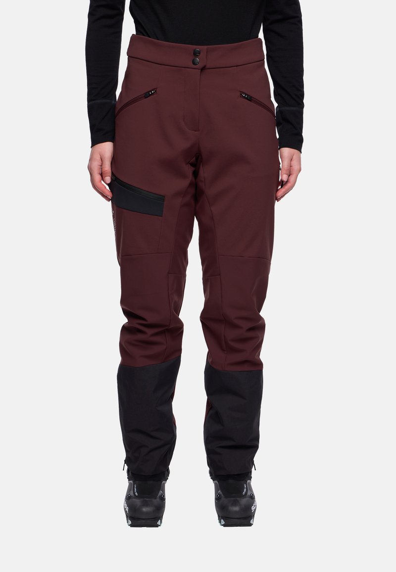 Heren skibroek in donker bordeauxrood met zwarte accenten. Voorzien van een knoopsluiting, ritszakken en taps toelopende pijpen. Gemaakt van duurzaam materiaal.