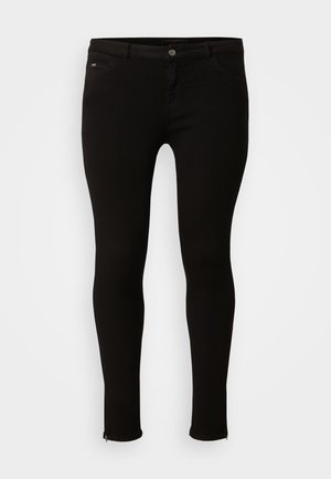 Black skinny jeans in stretch denim. Features a front button closure, two front pockets, and zippers at the ankle hems. Smooth texture.