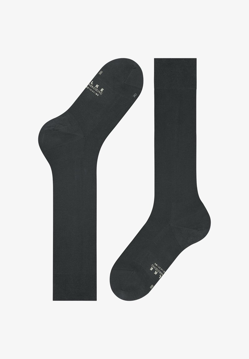 Due calzini neri al ginocchio stesi, uno mostra la parte superiore con il bordo a maglia, l'altro presenta la suola con testo bianco e indicazioni della misura.