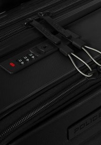 Schwarzer Koffer mit Struktur, ausgestattet mit zwei Reißverschlüssen, einem Zahlenschlossmechanismus und einem gummierten Markenpatch mit eingeprägtem Schriftzug "POLICE".