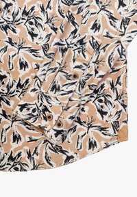 Camicia con motivo floreale nei toni del beige, nero e bianco. Presenta un tessuto testurizzato, dettagli con bottoni e un colletto ripiegato.