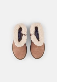 Botas de tobillo de ante sintético en tono marrón con un forro beige suave, puntera redondeada y plantilla acolchada. Con un pequeño tag de la marca en el interior.