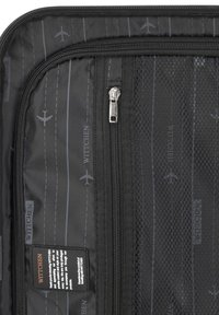 Zwarte reistas met een ritszak, geperforeerde voering en bedrukte vliegtuigontwerpen. Label zichtbaar met merknaam "Wittchen."