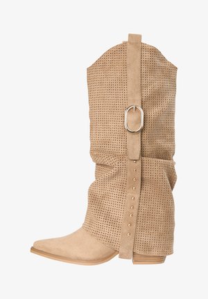 Botte mi-mollet en daim marron clair avec motif perforé, sangle verticale décorative avec boucle dorée et clous, et semelle plate en caoutchouc.