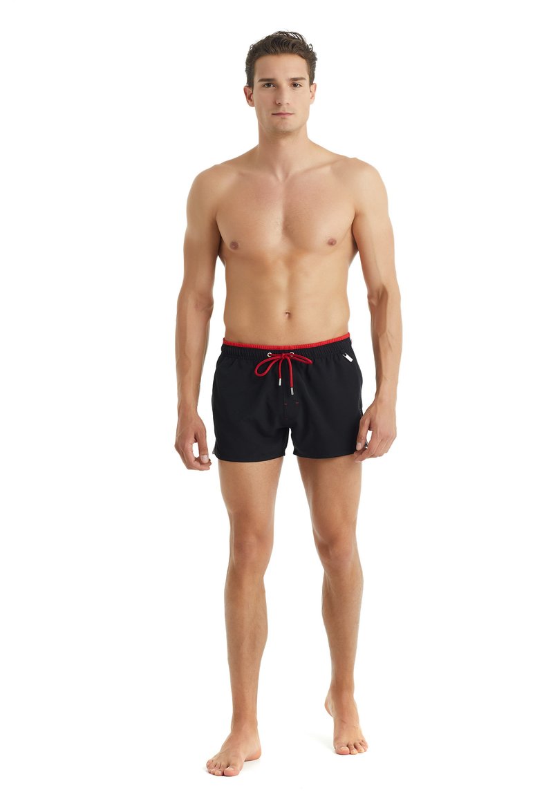 Shorts da bagno neri con cintura e cordino rossi, realizzati in materiale leggero, dotati di tasche laterali e con un design semplice.