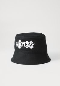 Cappello a secchiello nero in tessuto, con logo bianco "REPLAY" in caratteri logori. Texture liscia, visiera larga e dettagli in cucitura.