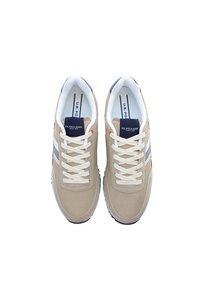 Beige idrottsskor med ovandel i mesh och textil, vita snörningar, marinblå detaljer och flerfärgade ränder. Svart gummisula.