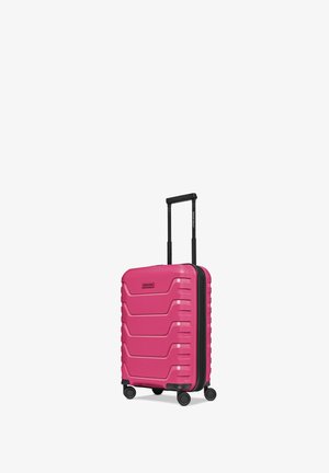 Valise rigide rose avec surface texturée, quatre roues pivotantes noires et poignée télescopique noire étendue.