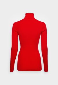 Punainen ribattua turtleneck-neule, jossa on pitkät hihat, sopiva muoto, saumatonta suunnittelua ja korkea kaulus. Pehmeä textures, ei näkyviä kuvioita tai tarvikkeita.