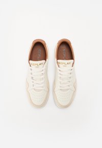 Kremfargede sneakers med lys brune detaljer, perforert tåboks og snøring. Merkevaren "REPLAY 1981" på tungen, teksturert skinnfinish.