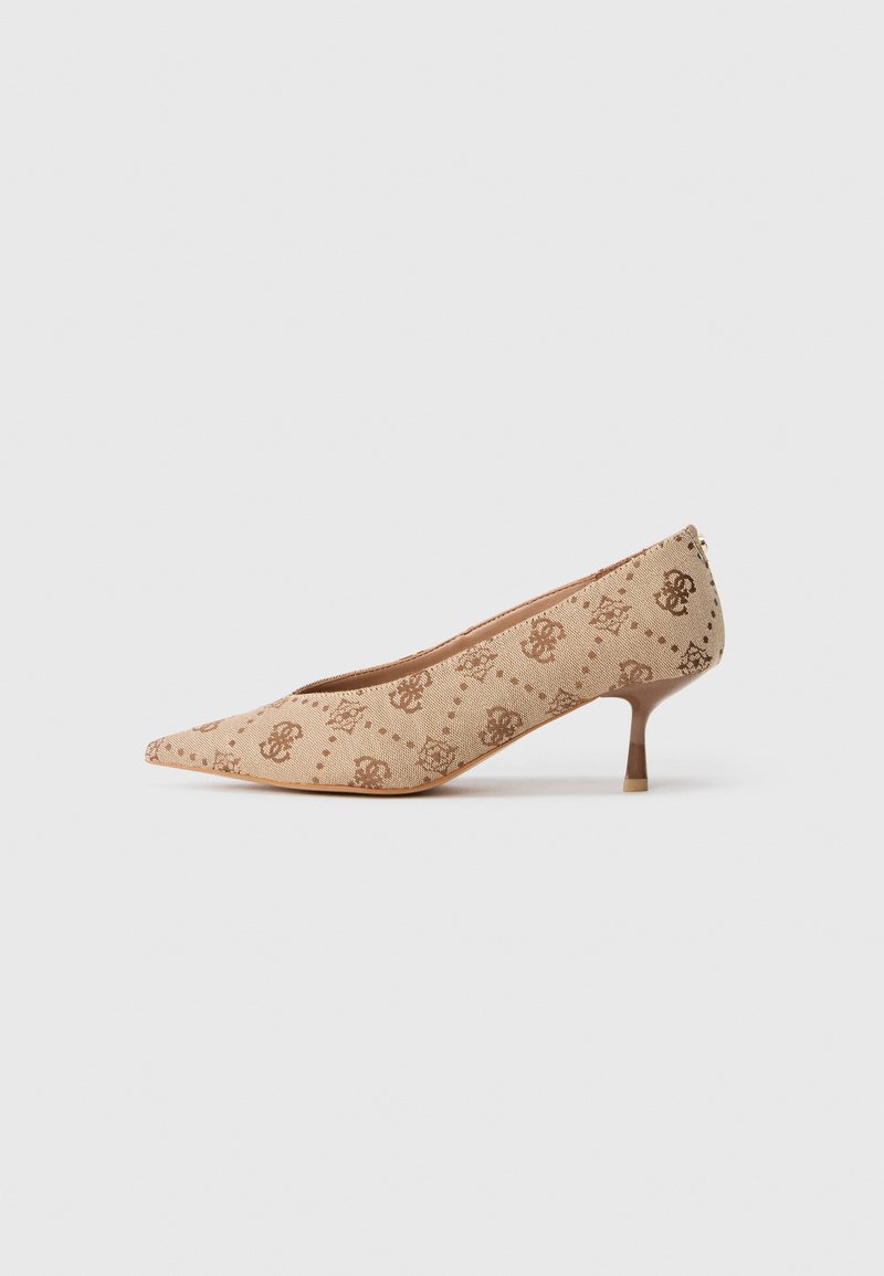 Beige spetsig tå kitten heel med brunt monogrammönster och låg stilettklack på en enfärgad vit bakgrund.