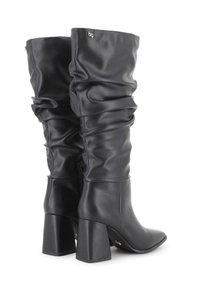 Botas negras hasta la rodilla con parte superior de cuero arrugado, tacones cuadrados y cremallera lateral, en ángulo para mostrar tanto la parte trasera como la exterior.