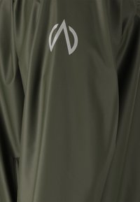 Wasserabweisende Jacke in olivgrün, mit einer eleganten, glatten Textur und einem auffälligen grauen Logo auf der linken Seite.