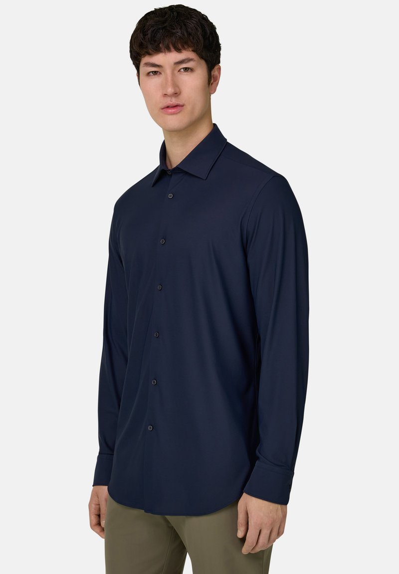 Chemise bleu marine à manches longues en tissu lisse, avec fermeture boutonnée à l'avant, col classique et coupe ajustée pour un look sur mesure.