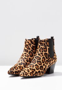 Leopardikuvioiset nilkkurit, jotka on tehty teksturoidusta turkiksesta, terävillä kärjillä ja matalalla lohkokorolla, joissa on mustat joustavat sivupaneelit.