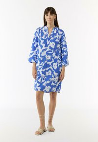 Kleid aus Baumwollmischung mit einem blau-weißen abstrakten Blumenmuster, Dreiviertelärmel und V-Ausschnitt, in mittlerer Oberschenkelhöhe.