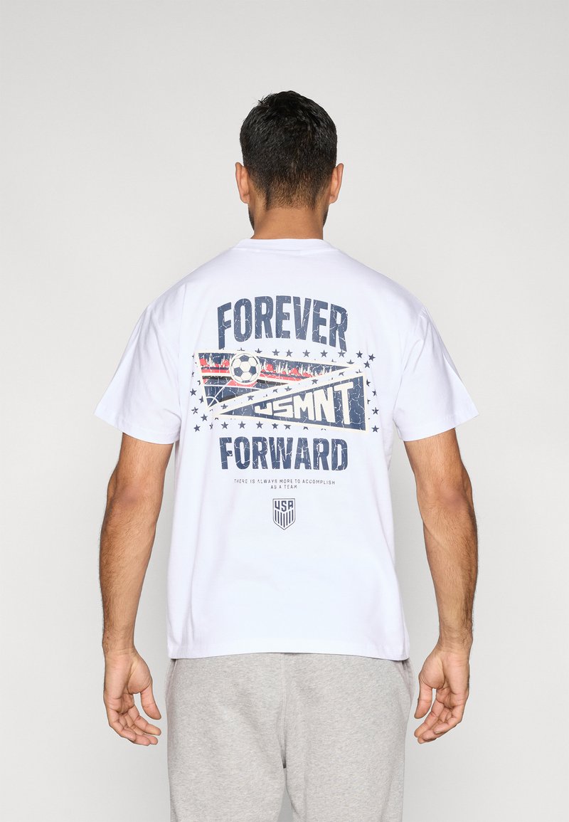T-shirt branca de algodão com o texto "FOREVER FORWARD" e um gráfico de bola de futebol, com detalhes em vermelho e azul e motivos de estrelas nas costas.