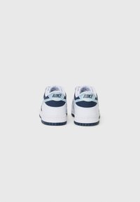 Vita lädersneakers med marinblå detaljer, med en texturerad baksidestpanel och logodetalj, samt en kontrasterande svart gummisul.