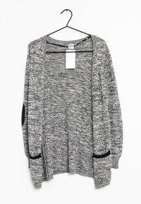 Cardigan a maglia grigio e nero mélange con apertura frontale, maniche lunghe e dettagli neri sulle tasche. Appeso a un gancio nero.