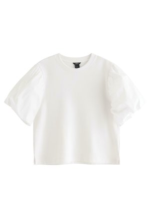 Hvid kortærmet bluse med puffede ærmer og rund halsudskæring, forkortet længde og en lille sideslids i kanten.