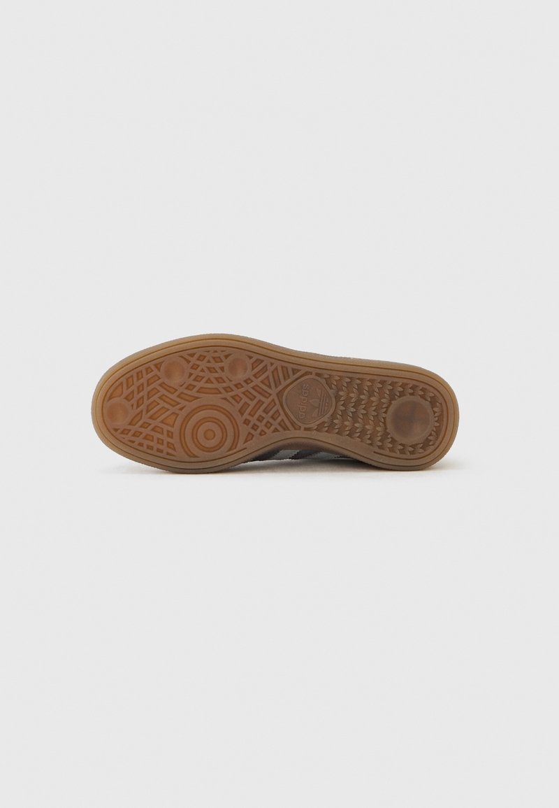 Rubber outsole with a textured pattern; features circular and geometric designs. Upper section is grey with a subtle sheen.