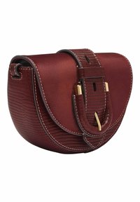 Petit sac en cuir bordeaux avec une finition texturée, forme incurvée, ferrures dorées et une bandoulière amovible. Détails de couture le long des bords.