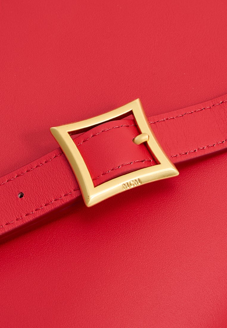 Rote Lederhandtasche mit einem goldenen quadratischen Schnallen-Detail am Träger. Glatte Oberfläche mit sichtbaren Nähten und einem eingravierten Logo auf der Schnalle.