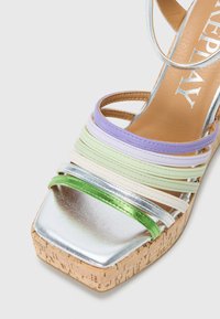 Multifargede sandaler med remmer som har metalliske sølvremmer, grønne detaljer, korksåle og firkantet tupp.