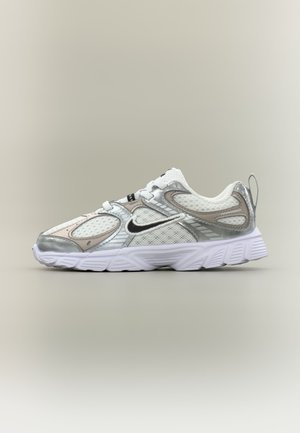 Biały i srebrny but do biegania Nike z siateczkowymi panelami, czarnym logo Swoosh i grubą, teksturowaną podeszwą, pokazany z profilu na neutralnym tle.