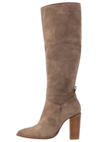 Bota marrón de gamuza hasta la rodilla con punta puntiaguda, superficie texturizada y tacón apilado de madera. Cuenta con una lengüeta para facilitar su colocación.