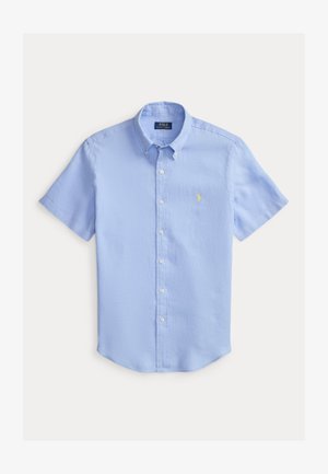 Camisa azul claro de manga corta con botones, cuello y pequeño logo amarillo bordado en el pecho, colocada plana sobre fondo blanco.