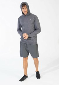 Herre langærmet hættebluse i mørkegrå, med glat overflade og tætsiddende design, parret med lette grå shorts og sorte sneakers.