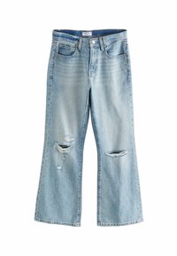 Lichtgewassen denim jeans met een uitlopende pijp, voorzien van versleten stukken en twee steekzakken. Eenvoudige stiksels. Geen zichtbare metalen onderdelen.
