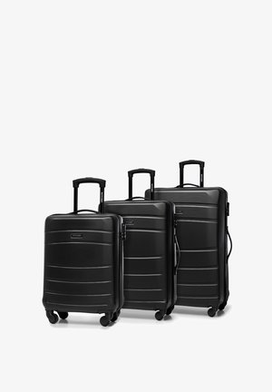 Tři černé tvrdé kufry různých velikostí s texturovaným designem, zapuštěnými rukojeťmi a čtyřmi koly pro jednoduchou mobilitu.